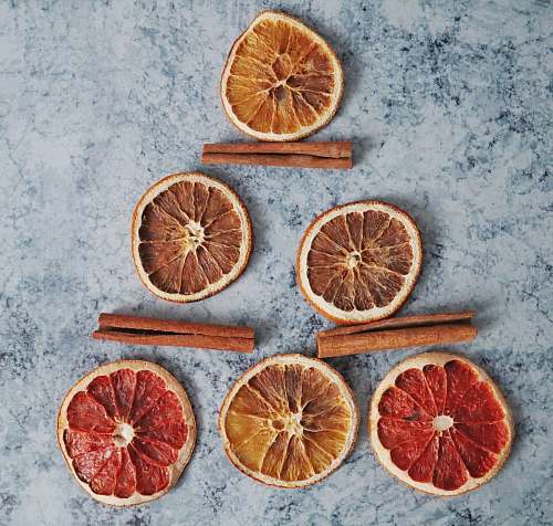 citrus fruit sliced grapefruit near three cinnamon plant